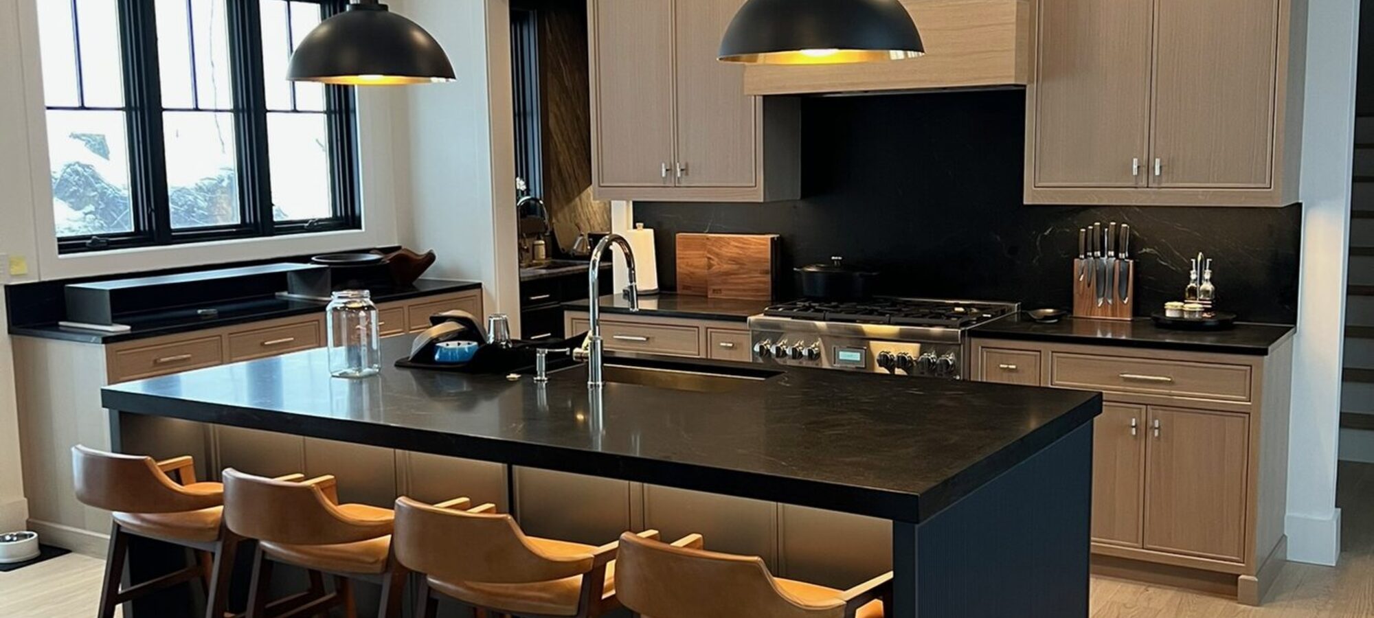 Custom kitchen cabinetry with a black island and pendant lighting