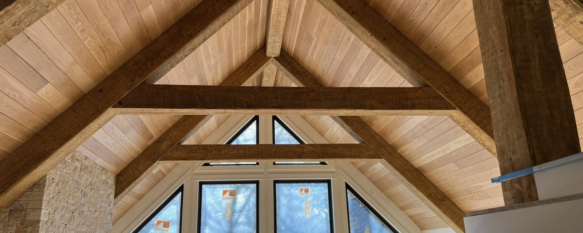 Exposed timber trusses under a tongue and groove cathedral ceiling
