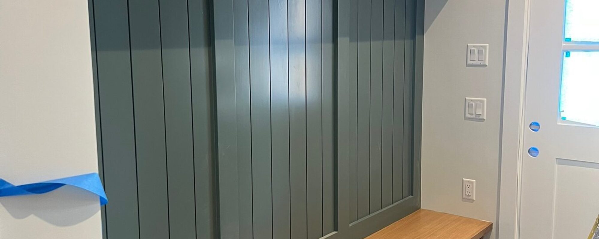 Board and batten paneling with a built-in bench and custom trim work