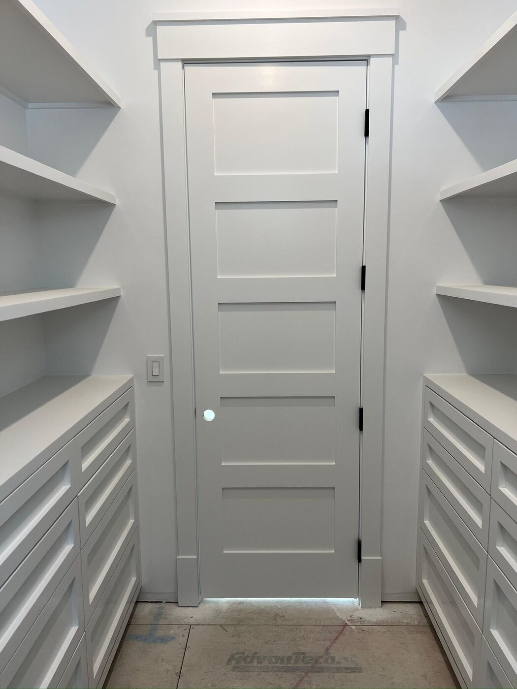 Walk-in pantry with a panel door, clean casing, open shelving and drawers