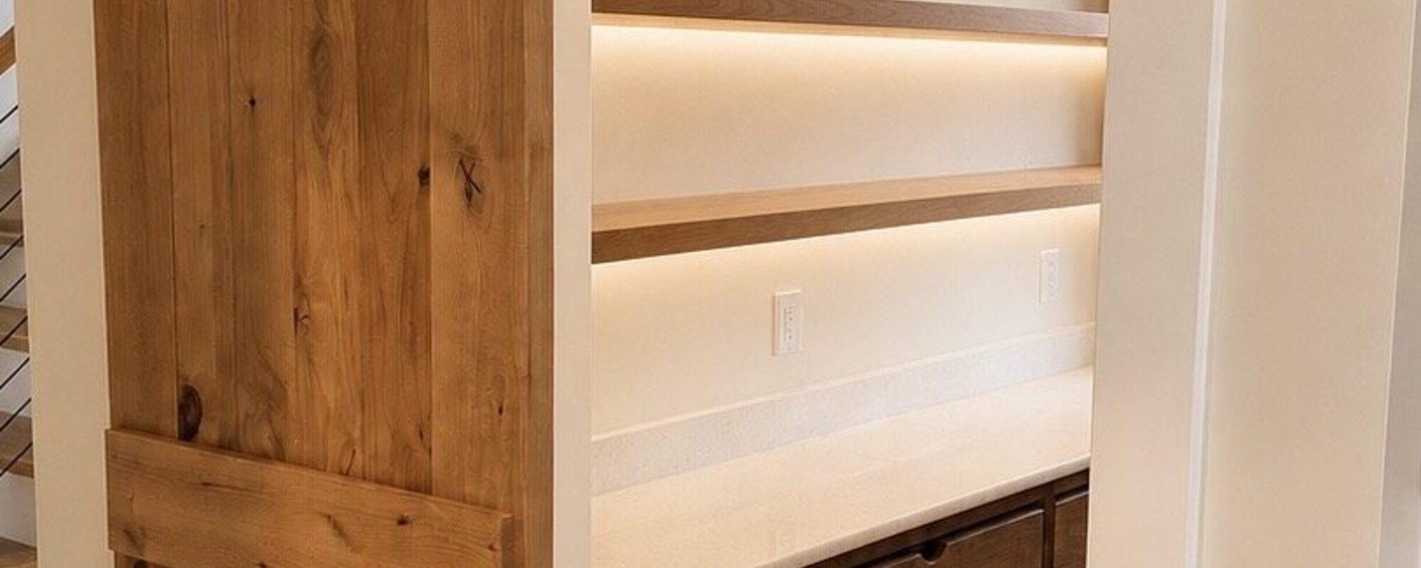Rustic barn door on a black track next to a custom wood closet